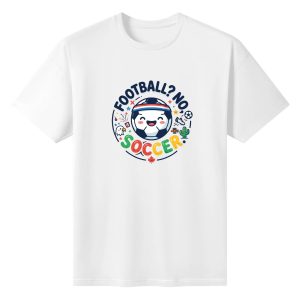 White oversized cotton short‑sleeve t‑shirt, front playful colorful circular “Football? No, Soccer.” typography print with cheerful kawaii soccer‑ball character, bald eagle, cactus, maple leaf and star confetti details, casual pro‑soccer North‑America‑themed tee flat lay