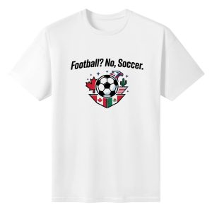 White oversized cotton short‑sleeve t‑shirt, front sleek clean “Football? No, Soccer.” typography paired with shield‑style soccer‑ball emblem featuring Canada‑USA‑Mexico flags, maple leaf, eagle and cactus details, casual pro‑soccer sports‑themed tee flat lay