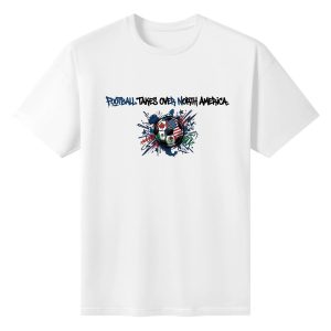 Plain white short‑sleeve crew‑neck t‑shirt with splatter‑art soccer ball graphic printed with host‑country flags and bold “Football Takes Over North America” street‑style typography