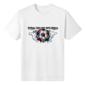 Plain white short‑sleeve crew‑neck t‑shirt featuring street‑drip graffiti soccer‑ball graphic with host‑country flag colors, North America map outline and bold “Football Takes Over North America” typography