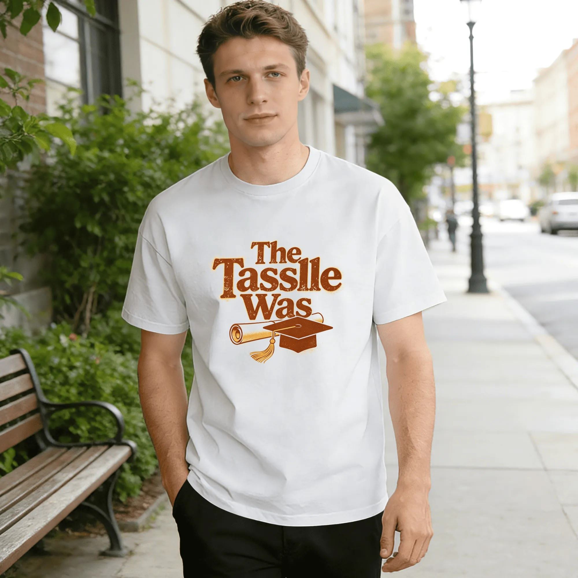 Model wearing the white “The Tassle Was” graduation tee outdoors, showcasing the relaxed fit and vintage-inspired design.