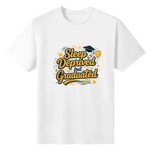 White crewneck T-shirt with a playful “Sleep Deprived but Graduated” graphic, featuring yellow lettering, graduation cap, diploma, balloon, and star accents.