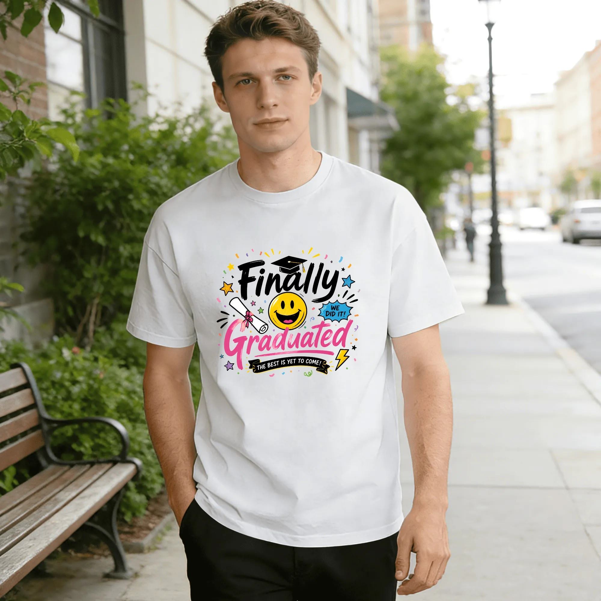 Model wearing the white “Finally Graduated” graduation tee outdoors, showcasing the relaxed fit and fun, joyful design.