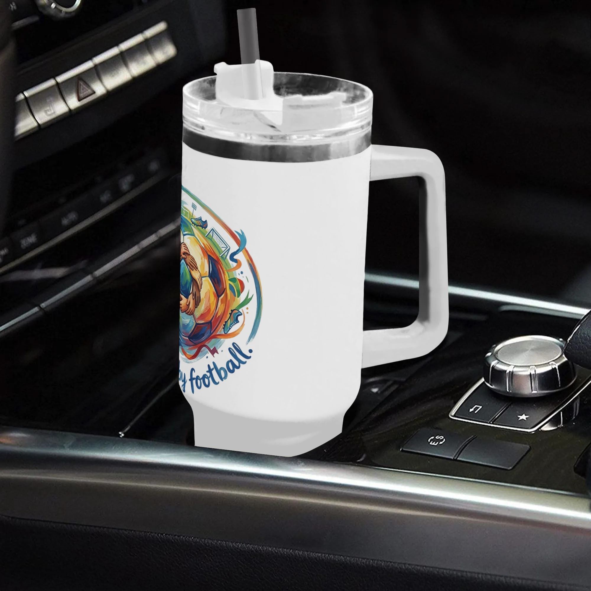 "united by football" tumbler placed in a car cup holder, showing its fit for on-the-go use.
