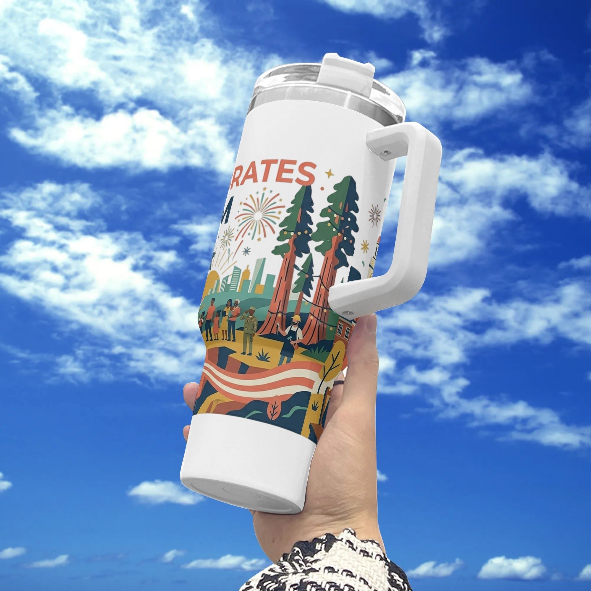 Handheld outdoor shot against blue cloudy sky, white 40oz insulated tumbler with full-wrap patriotic USA 250th print featuring redwood trees, celebratory crowds, American flag stripes and fireworks.