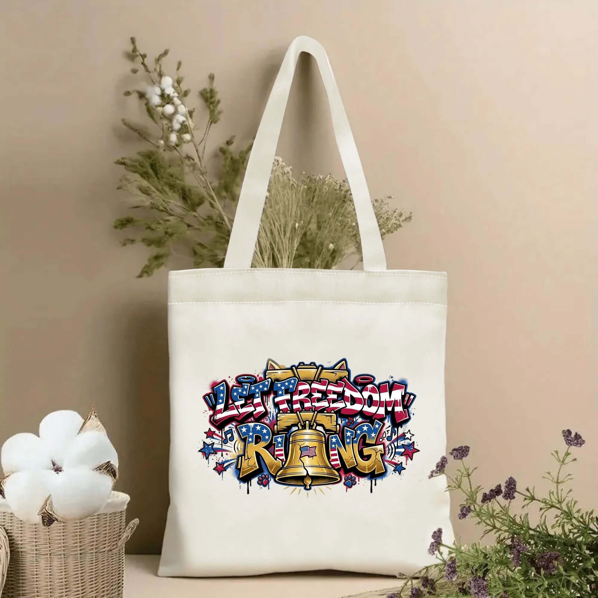 Wall floral shot: Natural canvas tote bag with USA flag patterned graffiti Let Freedom Ring + golden Liberty Bell patriotic print, farmhouse flower backdrop display