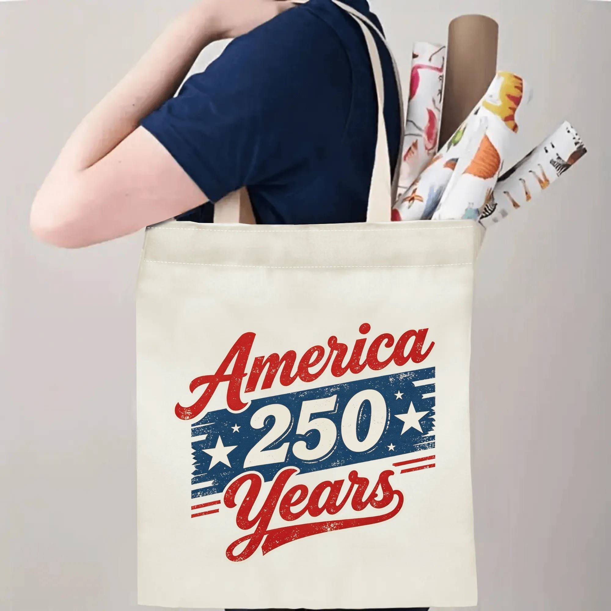 Person wearing the tote bag on their shoulder, showing handle length and print placement