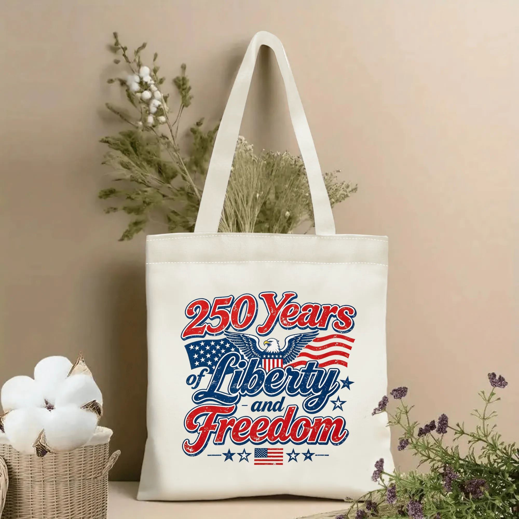 Patriotic tote bag with “250 Years of Liberty and Freedom” eagle and flag print, styled with dried flowers in a home setting.