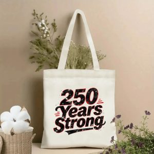 Lifestyle shot of the “250 Years Strong” canvas tote bag, styled with dried flowers in a home setting