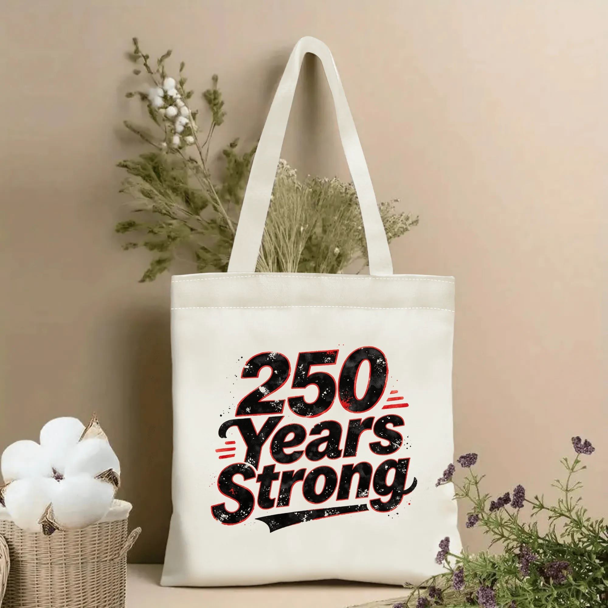 Lifestyle shot of the “250 Years Strong” canvas tote bag, styled with dried flowers in a home setting