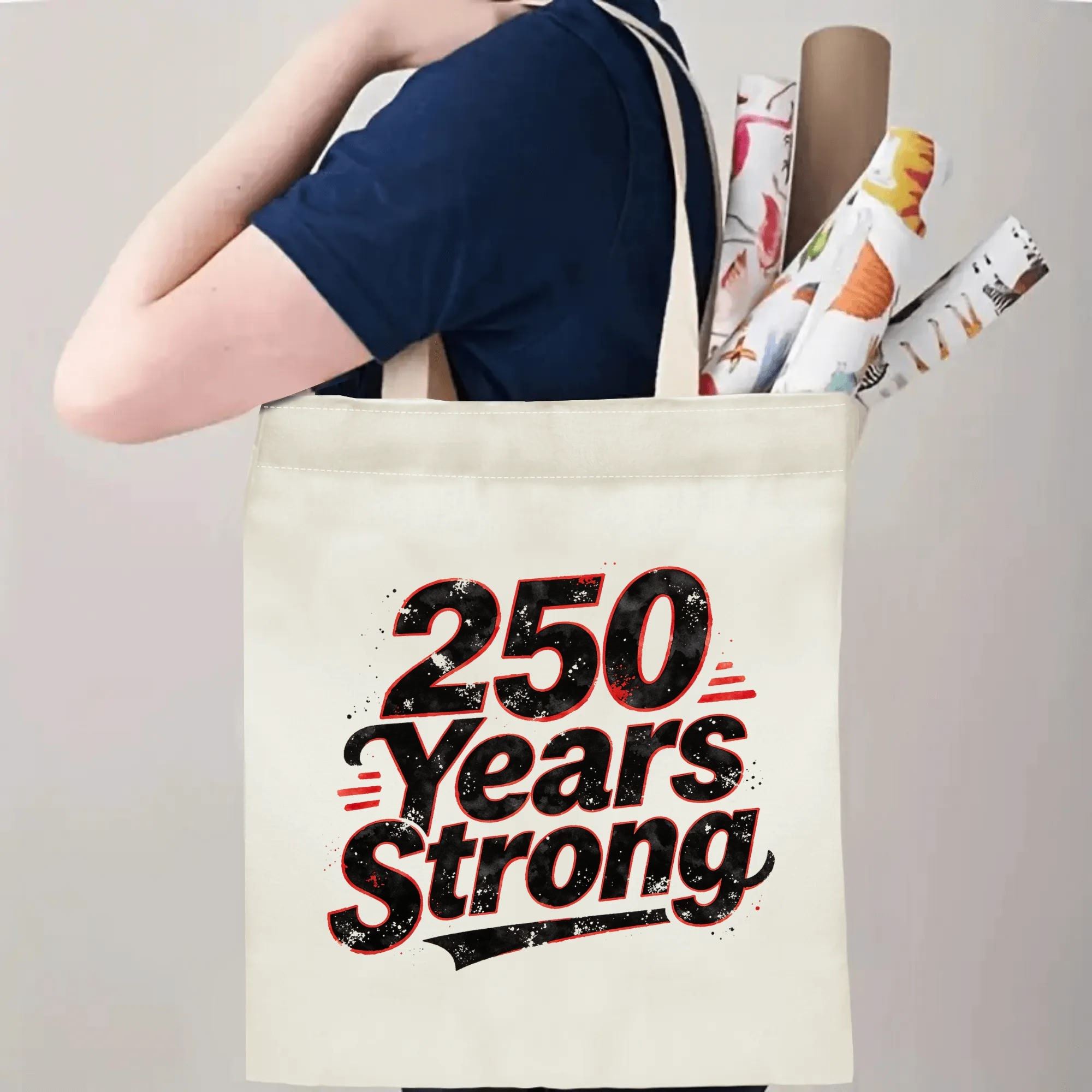 Person carrying the “250 Years Strong” tote bag, demonstrating handle length and print placement when worn