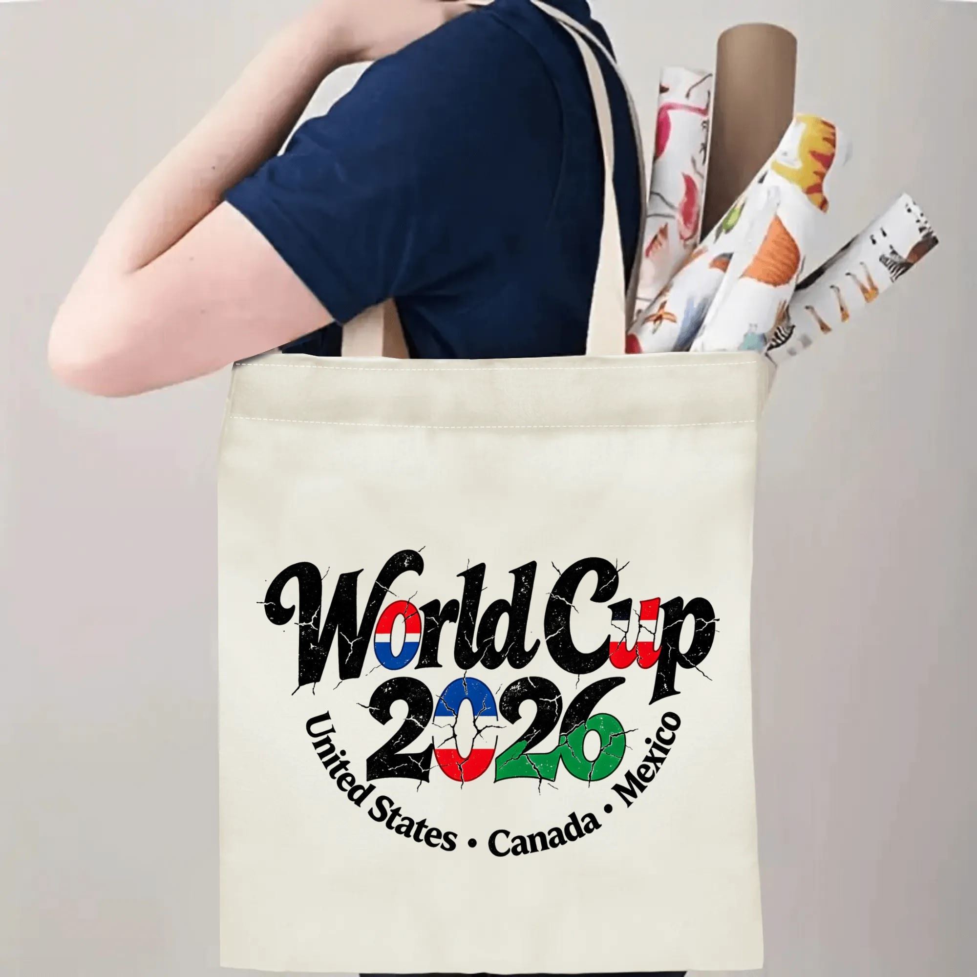 Person carrying the “World Cup 2026” distressed-style tote bag over the shoulder, demonstrating its size and practical use.