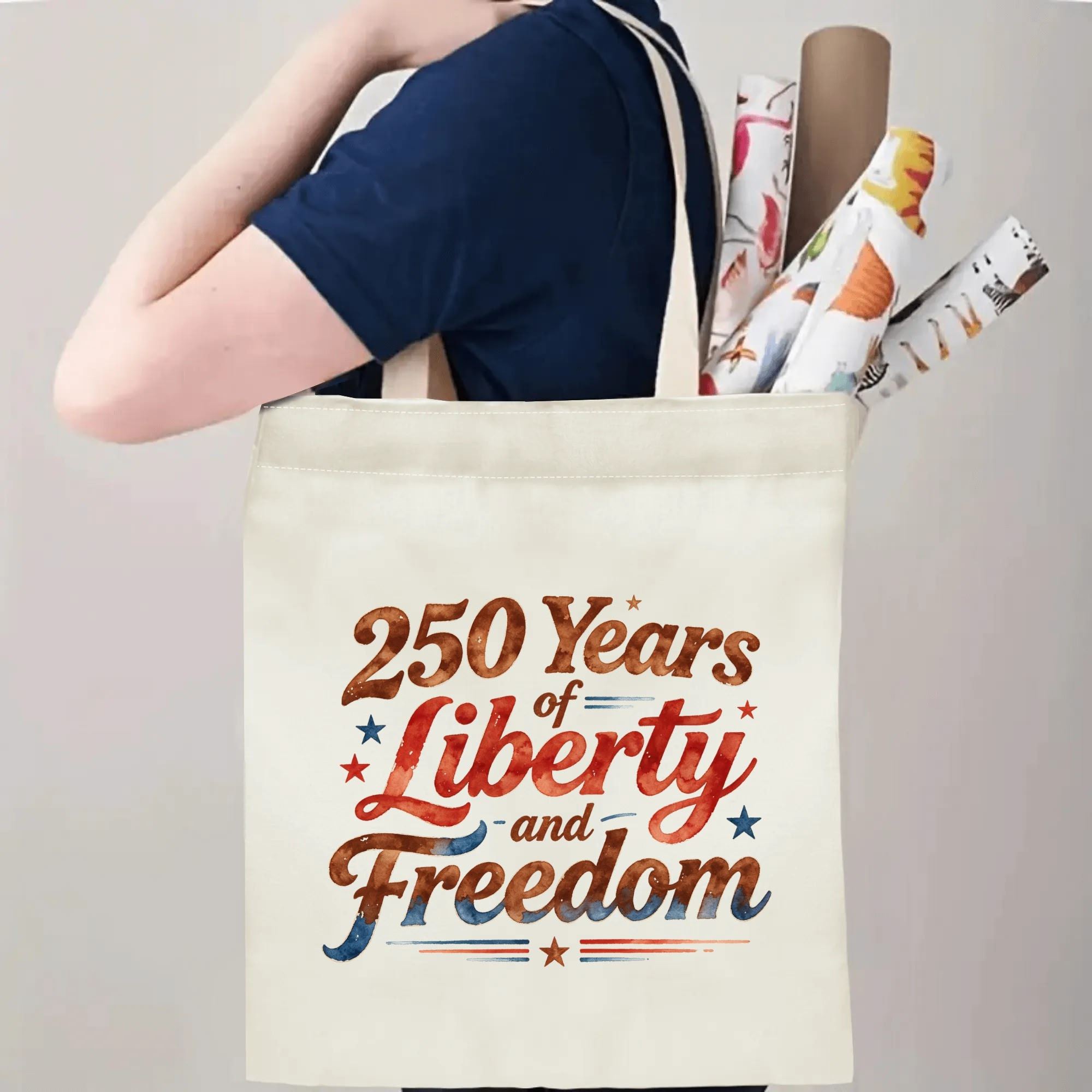 Person wearing the "250 Years of Liberty and Freedom" tote bag over their shoulder, showing its use as a carryall bag.