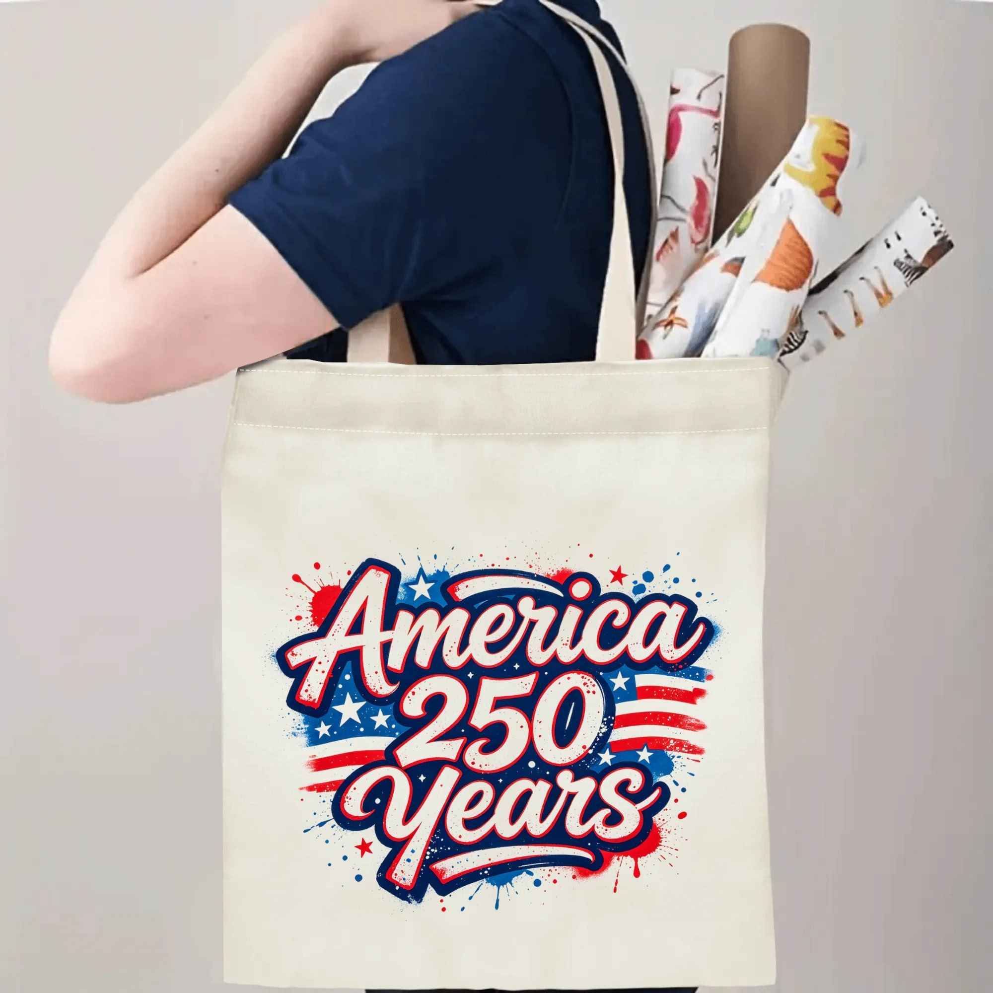 Person wearing the tote bag over their shoulder, showing the print from the side, with rolled-up items peeking out.
