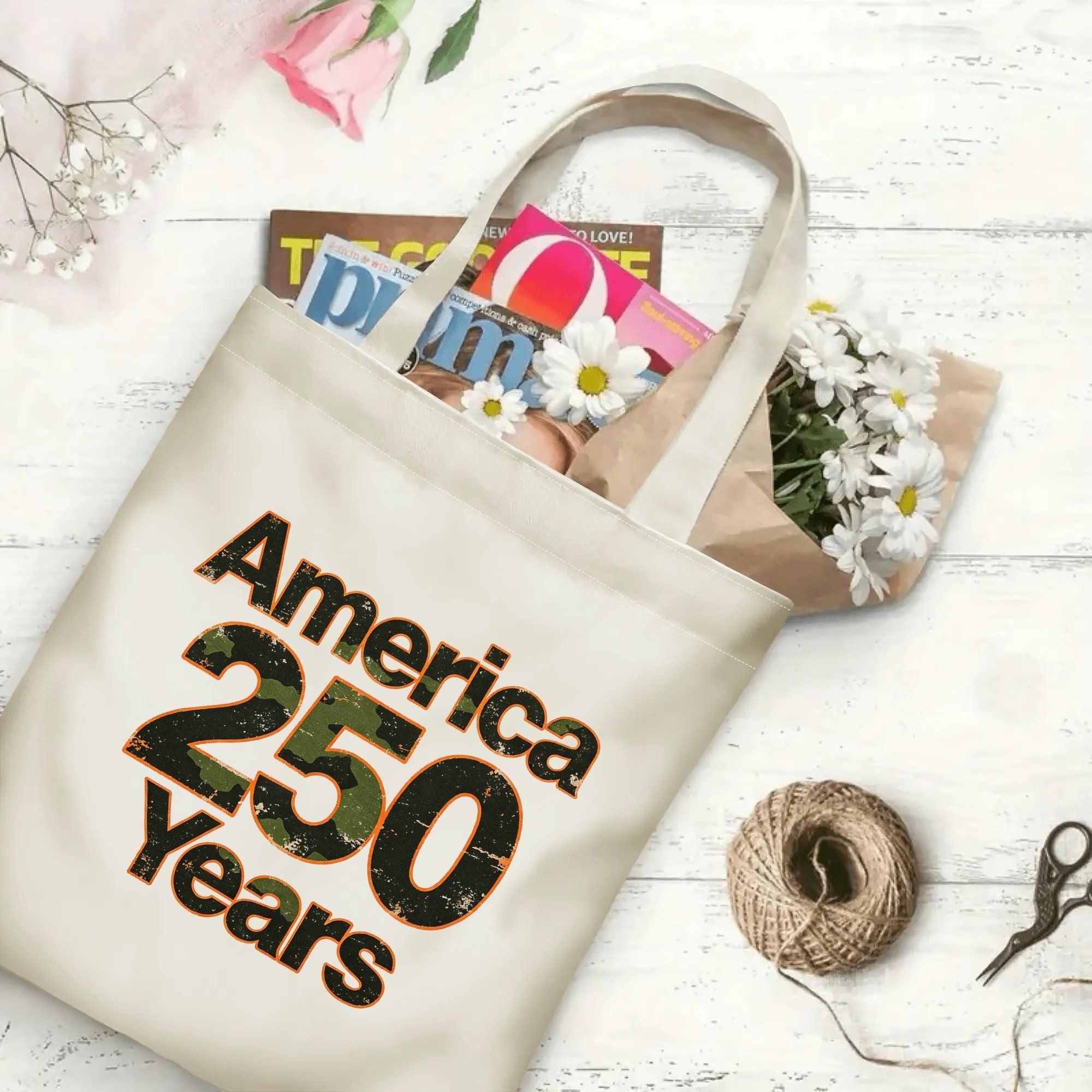 The same tote bag shown open, filled with books, magazines, and flowers, displaying its spacious capacity and print clearly.