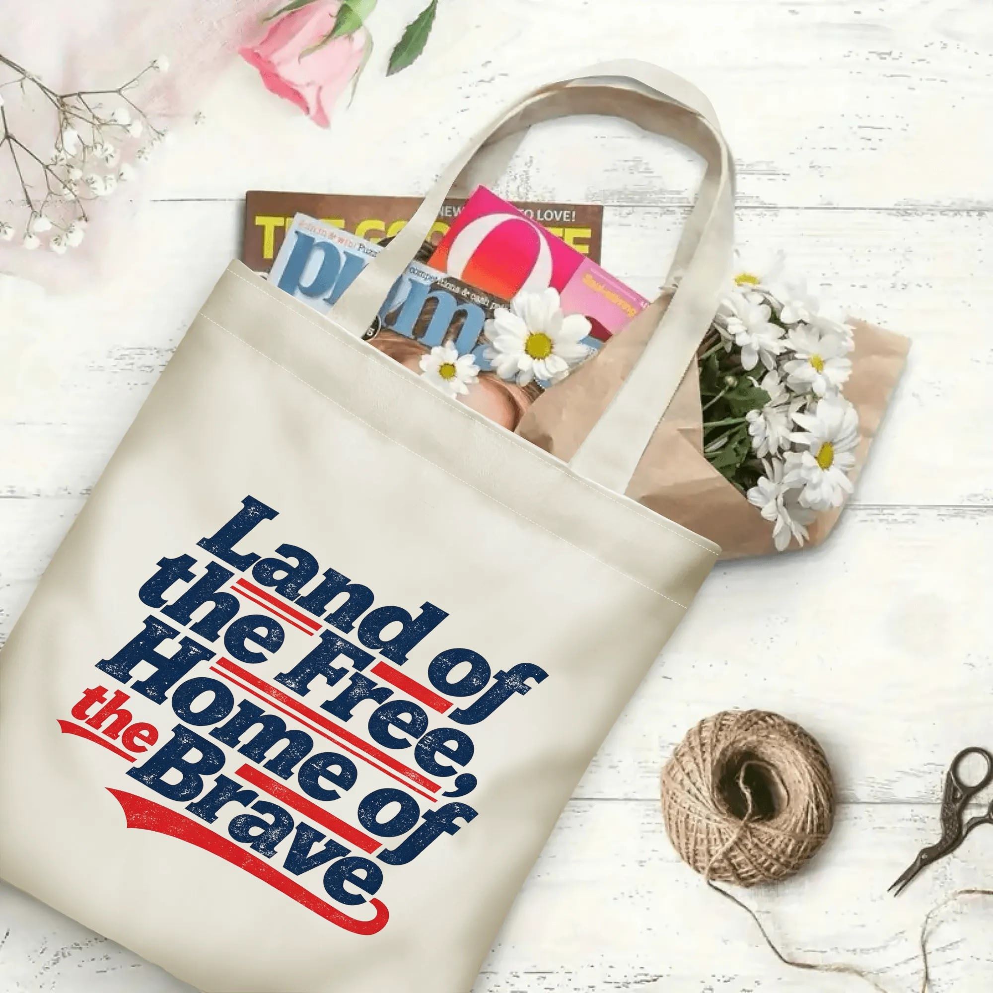 The same tote bag shown open, filled with books, magazines, and flowers, displaying its spacious capacity and print clearly.