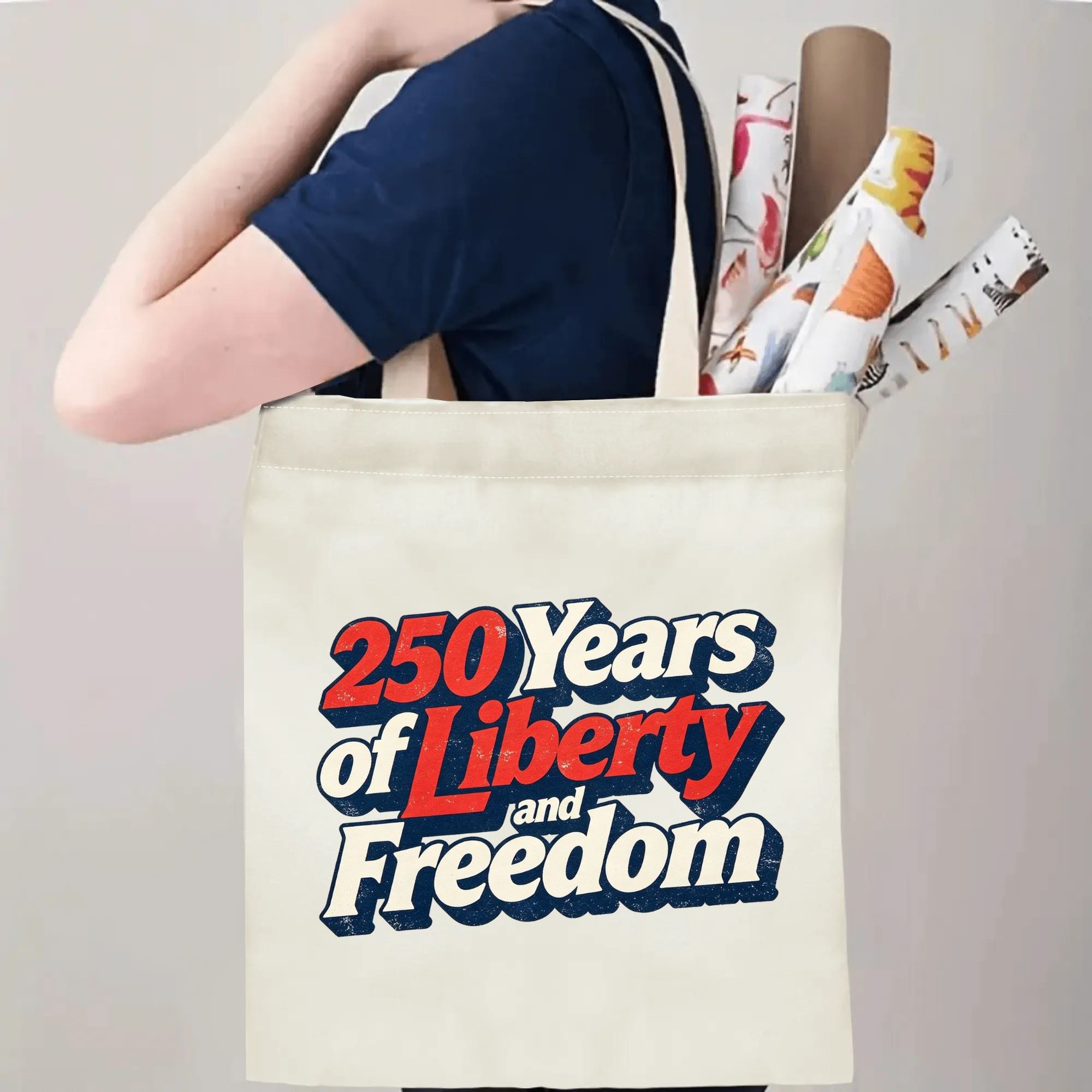 Person wearing the tote bag over their shoulder, showing the print from the side, with rolled-up items peeking out.