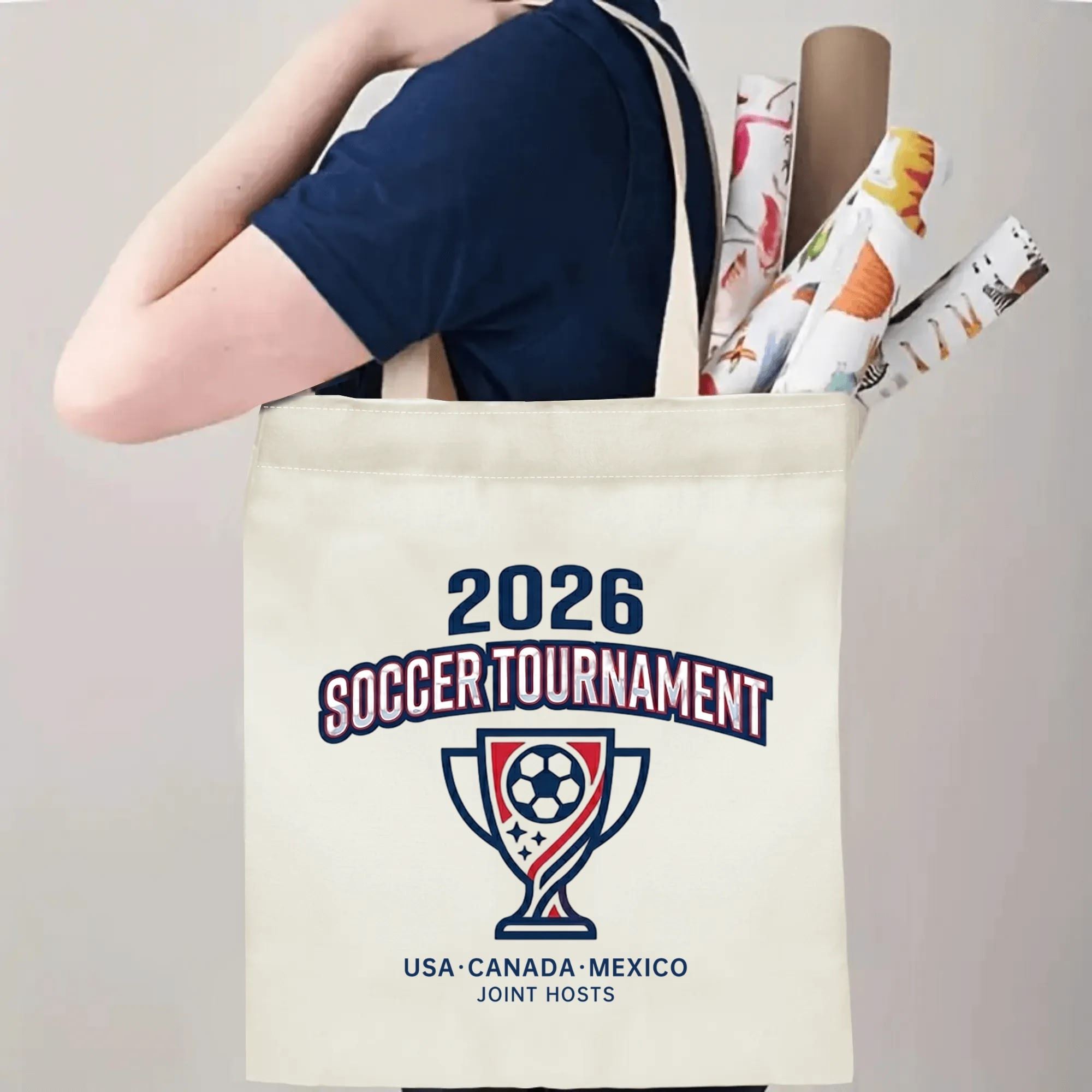 Person slinging 2026 World Cup USA Canada Mexico trophy emblem polyester canvas tote bag over shoulder, large capacity athletic football supporter carry bag for stadium outings