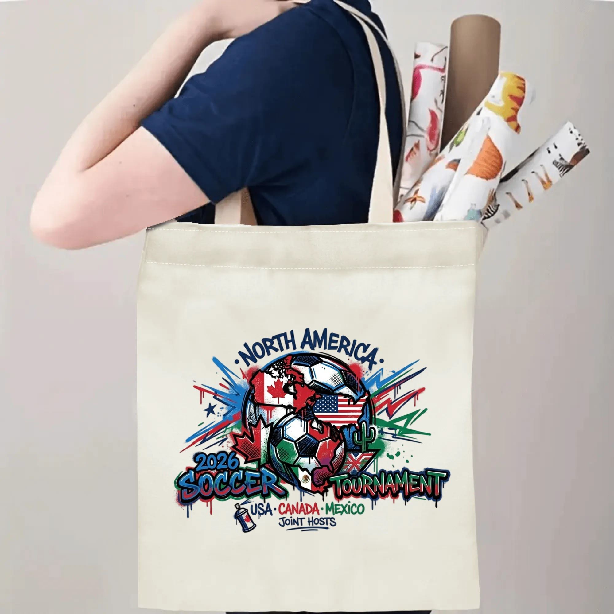 Person carrying 2026 USA Canada Mexico graffiti soccer tote bag over shoulder, large capacity streetwear football supporter bag for stadium trips