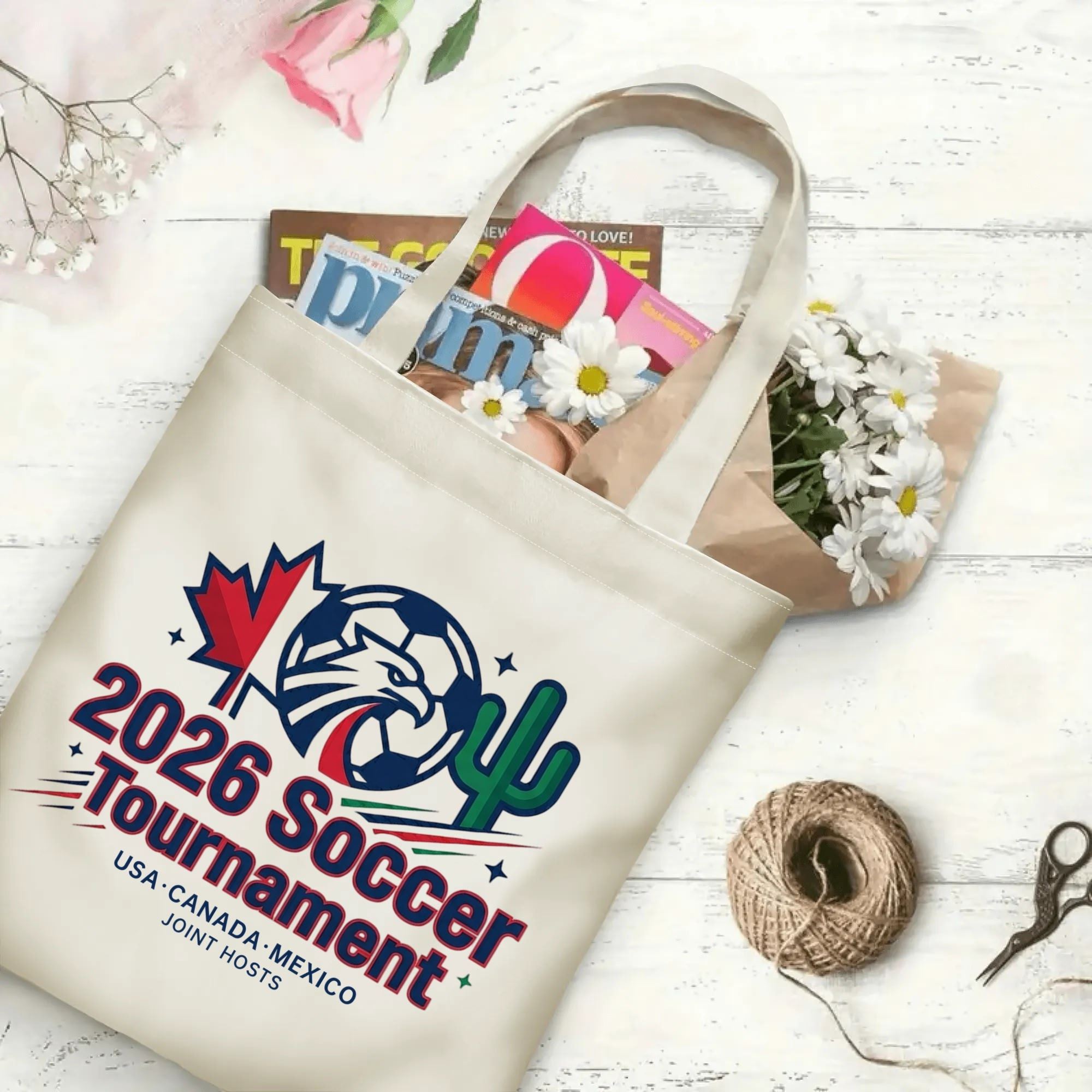 Minimal eagle soccer national symbol graphic canvas tote bag laid flat with magazines and daisies, reusable sport fan daily shopping bag