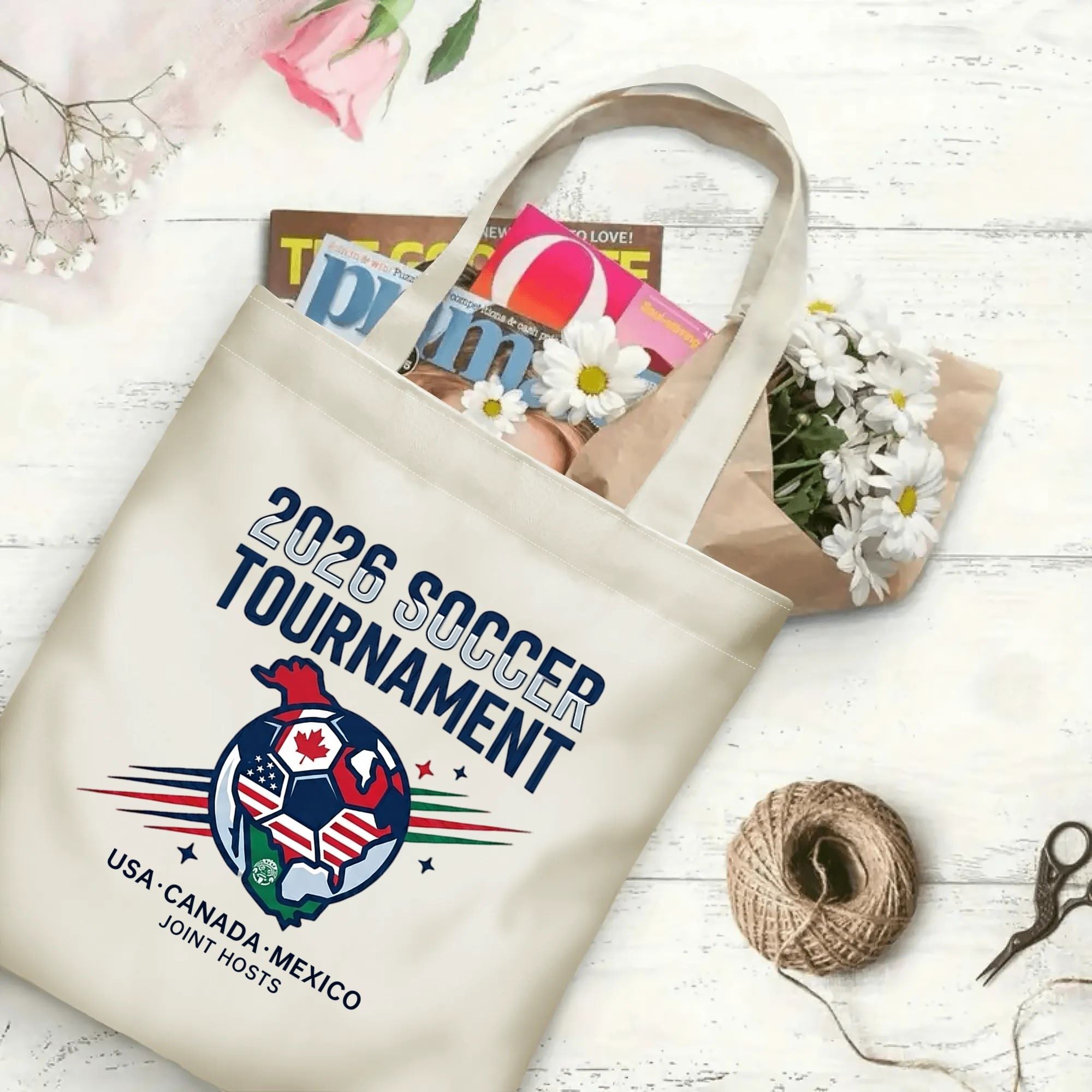 2026 soccer tournament joint host logo polyester canvas tote bag laid flat with magazines, daisies and twine, reusable fan daily shopping bag