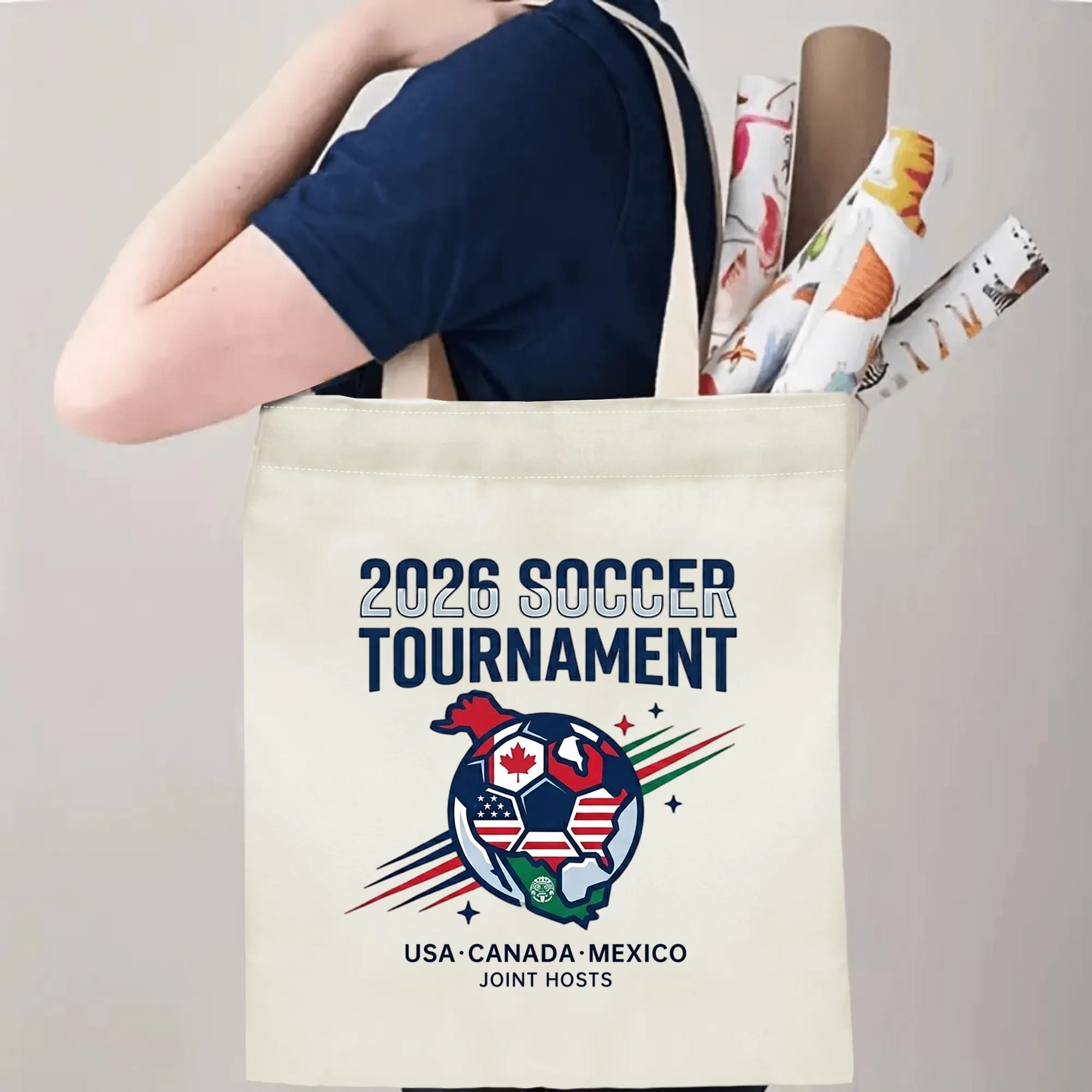 Person slinging 2026 World Cup USA Canada Mexico globe graphic polyester canvas tote bag over shoulder, large capacity football supporter carry bag for stadium outings