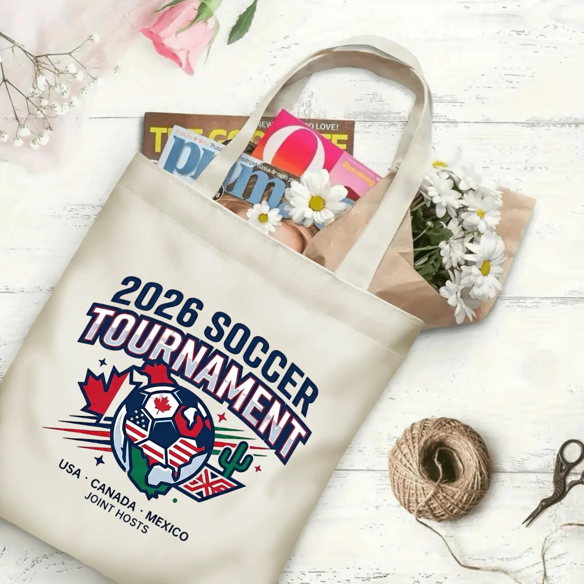 2026 Soccer Tournament world map soccer graphic canvas tote bag flat laid with magazines, daisies and twine, reusable sport fan daily shopping bag
