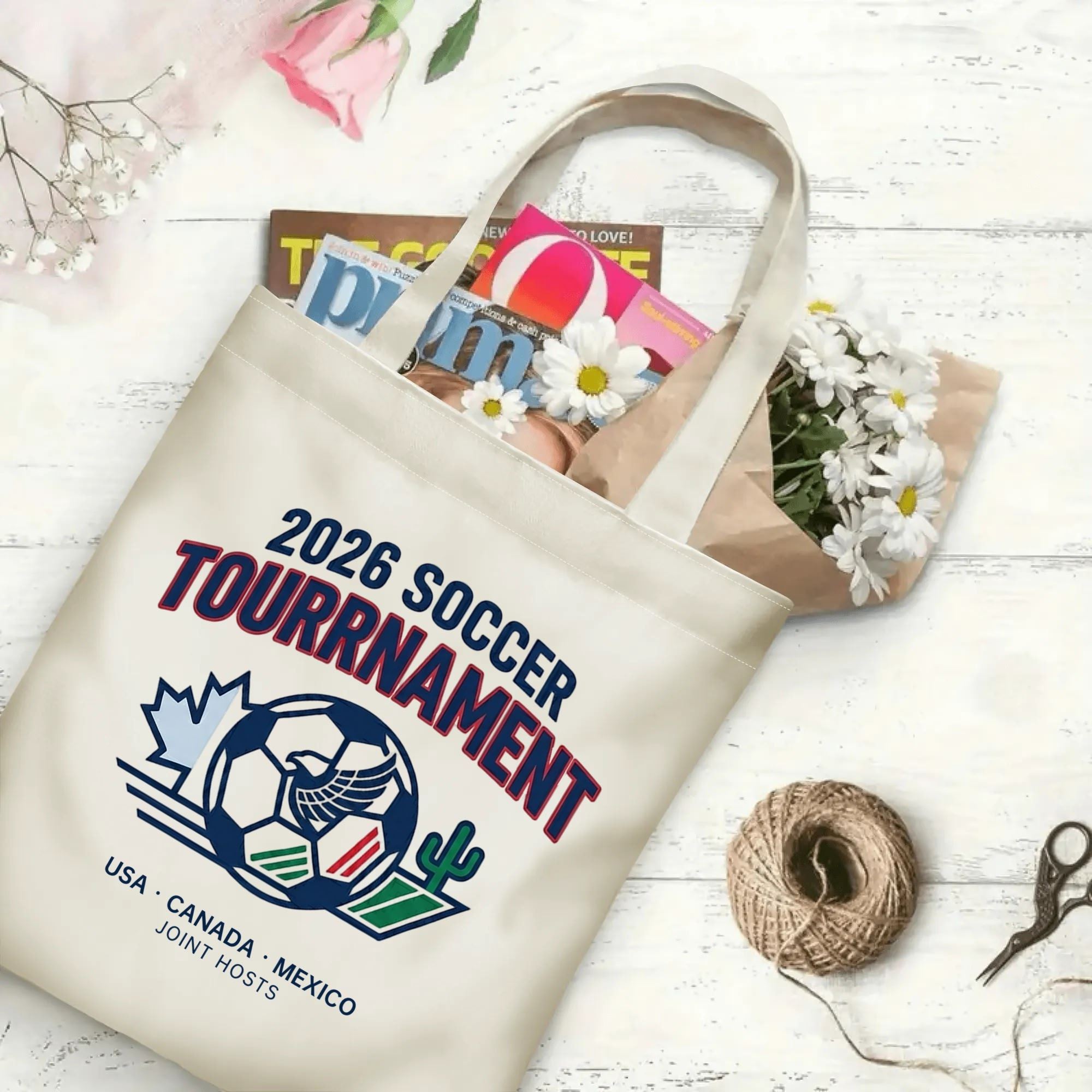 Retro varsity eagle soccer graphic canvas tote bag laid flat with magazines and daisies, reusable classic sport fan daily shopping bag