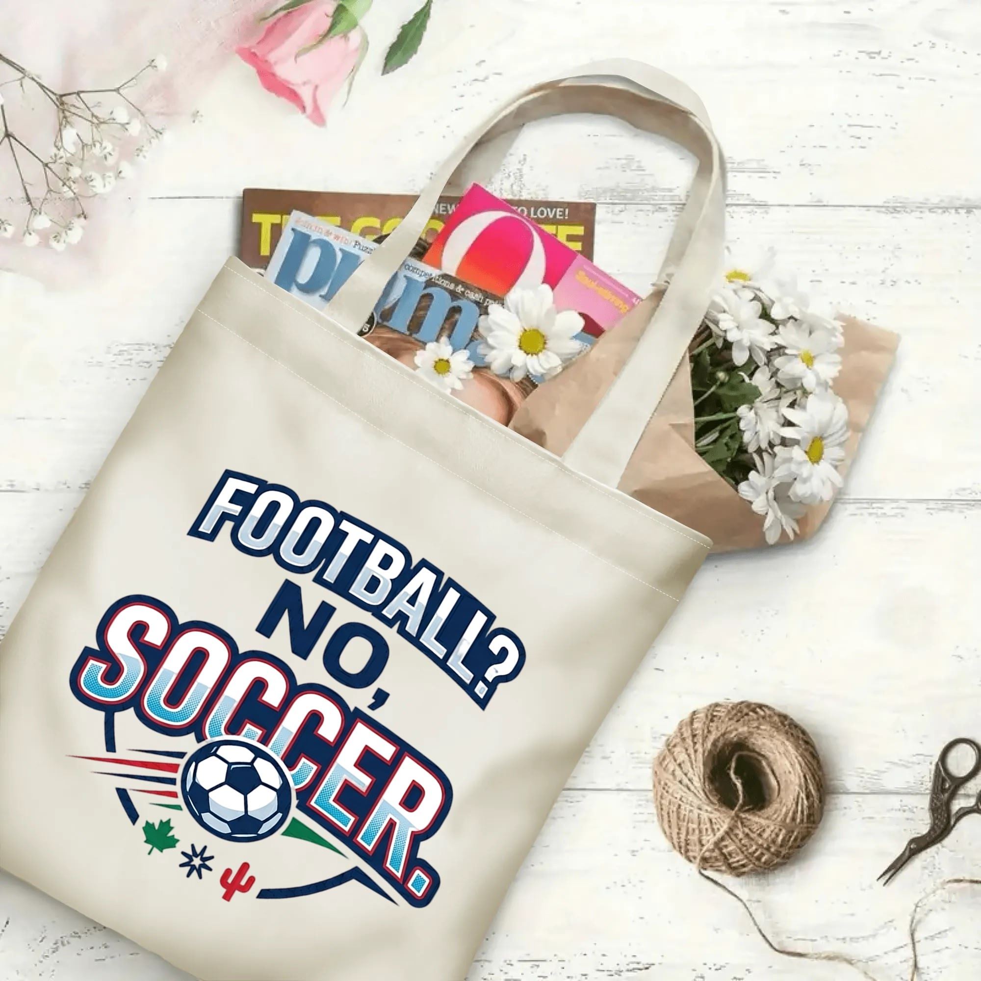 Funny soccer quote sport graphic canvas tote bag laid flat with magazines and daisies, reusable casual sport fan daily shopping bag