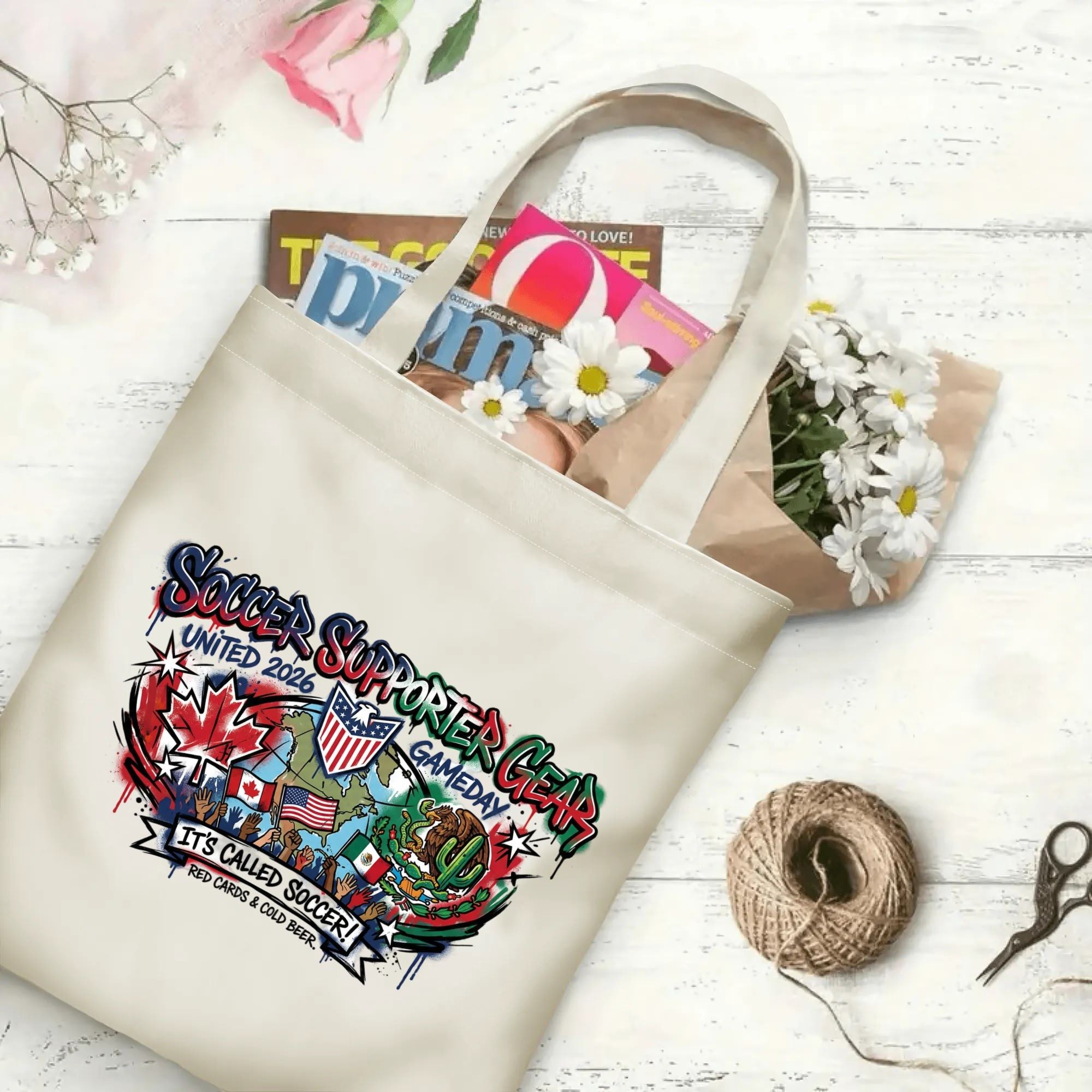 Color splash street art map flag soccer graphic canvas tote bag laid flat with magazines and daisies, reusable urban gameday sport fan daily shopping bag