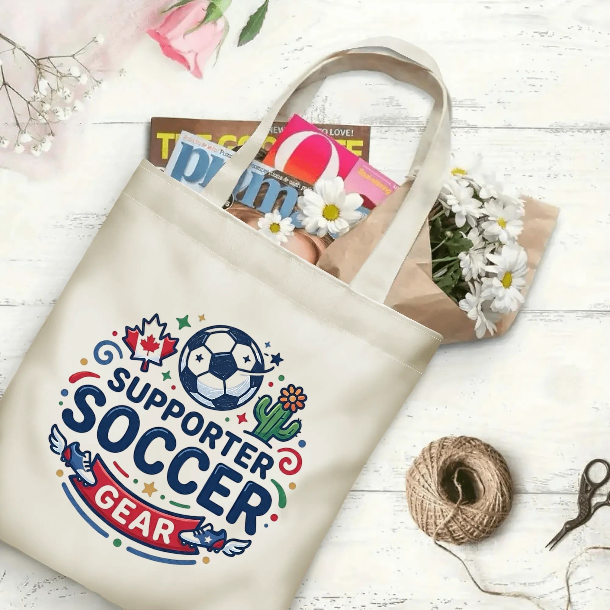 Sport soccer ball cleat graphic canvas tote bag laid flat with magazines and daisies, reusable casual sport fan daily shopping bag