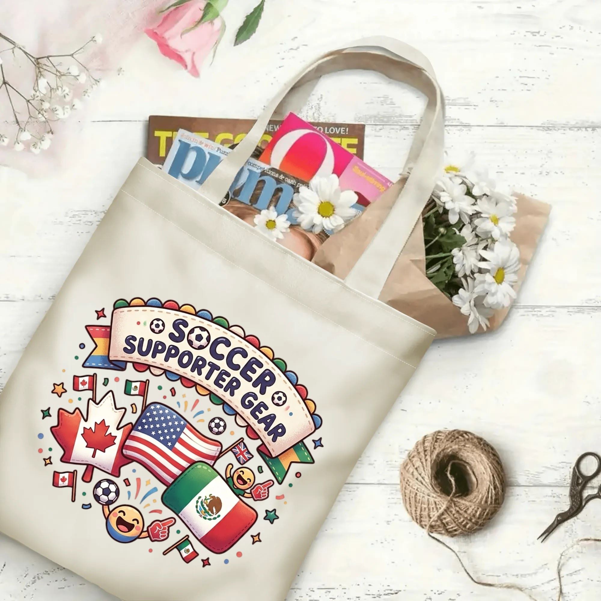 Playful confetti ribbon banner cartoon flag soccer graphic canvas tote bag laid flat with magazines and daisies, reusable cheerful gameday sport fan daily shopping bag