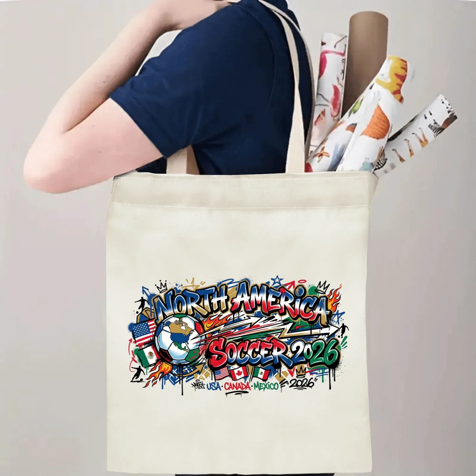 Person slinging 2026 USA Canada Mexico urban graffiti soccer badge canvas tote bag over shoulder, large capacity bold streetwear football supporter carry bag for stadium trips