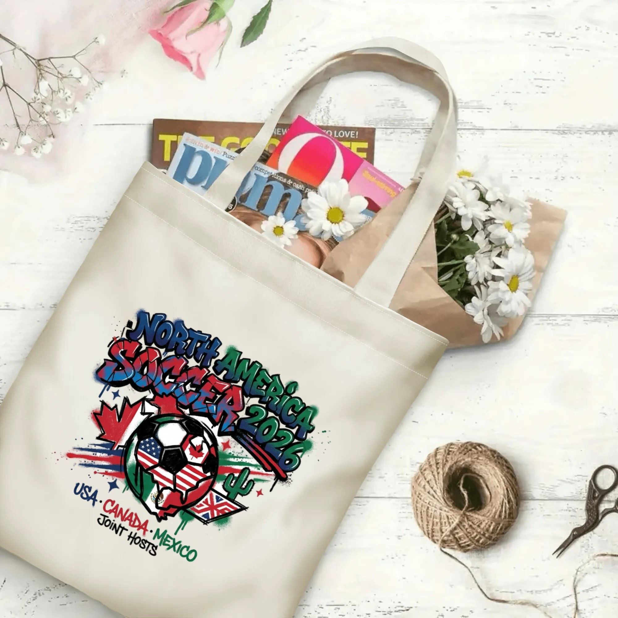 2026 football tournament splash ink graffiti North America soccer polyester canvas tote bag flat laid with magazines, daisies and twine, reusable street style fan daily shopping bag