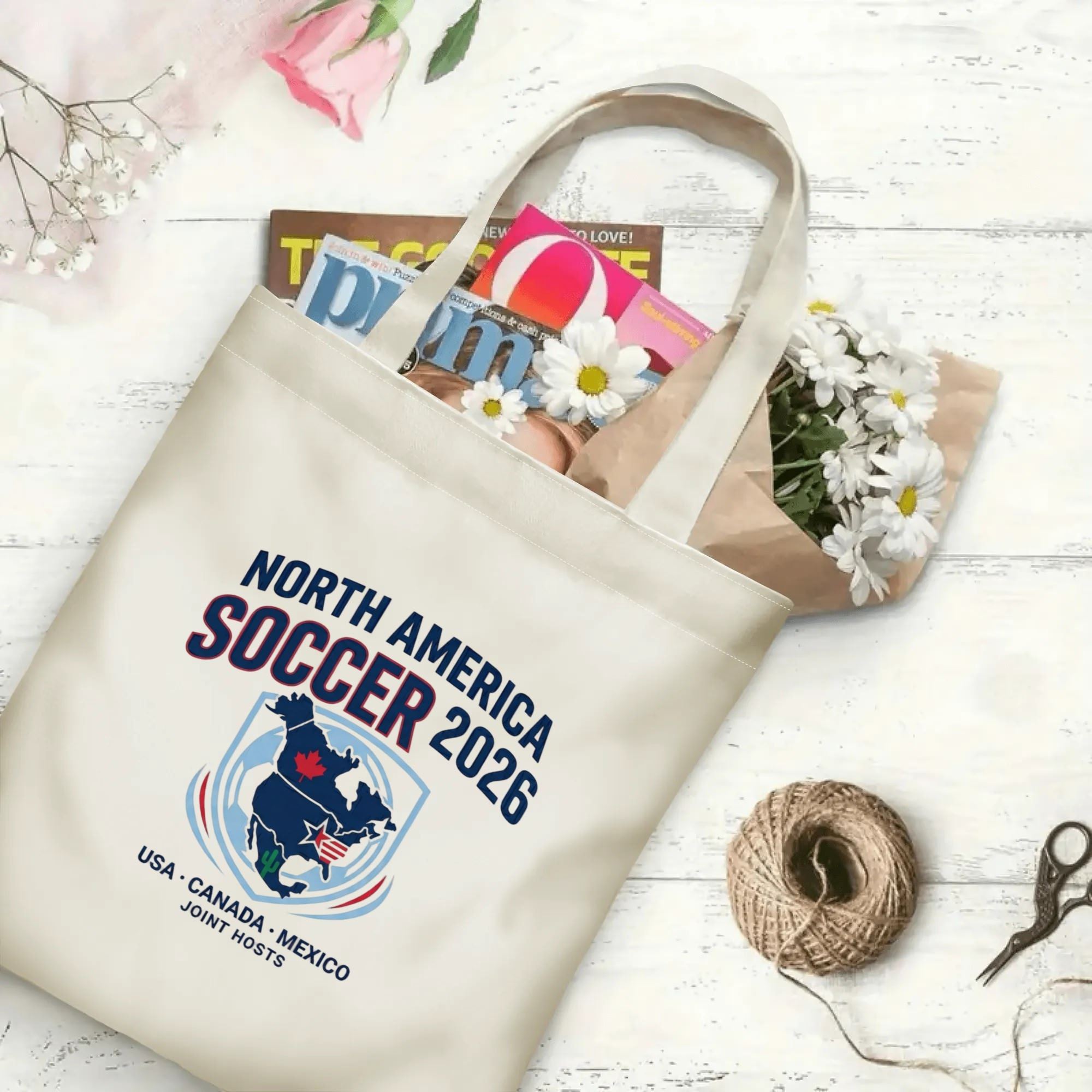 Minimal North America soccer map graphic canvas tote bag laid flat with magazines and daisies, reusable sport fan daily shopping bag