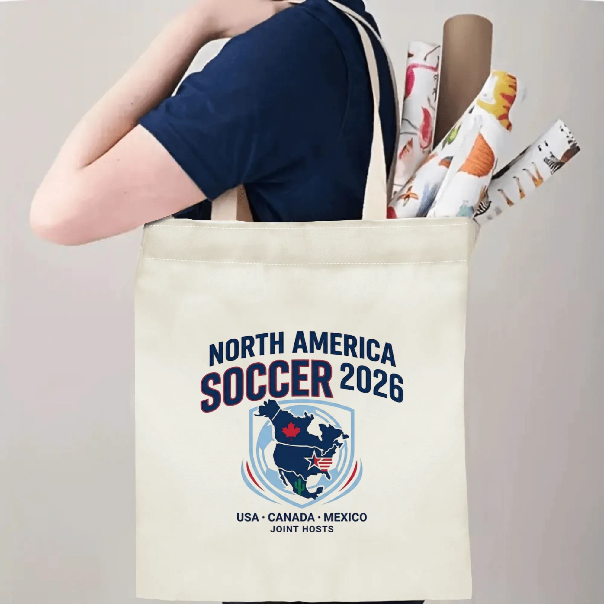 Person carrying 2026 USA Canada Mexico continent map shield canvas tote bag over shoulder, large capacity vintage football fan bag for stadium outings