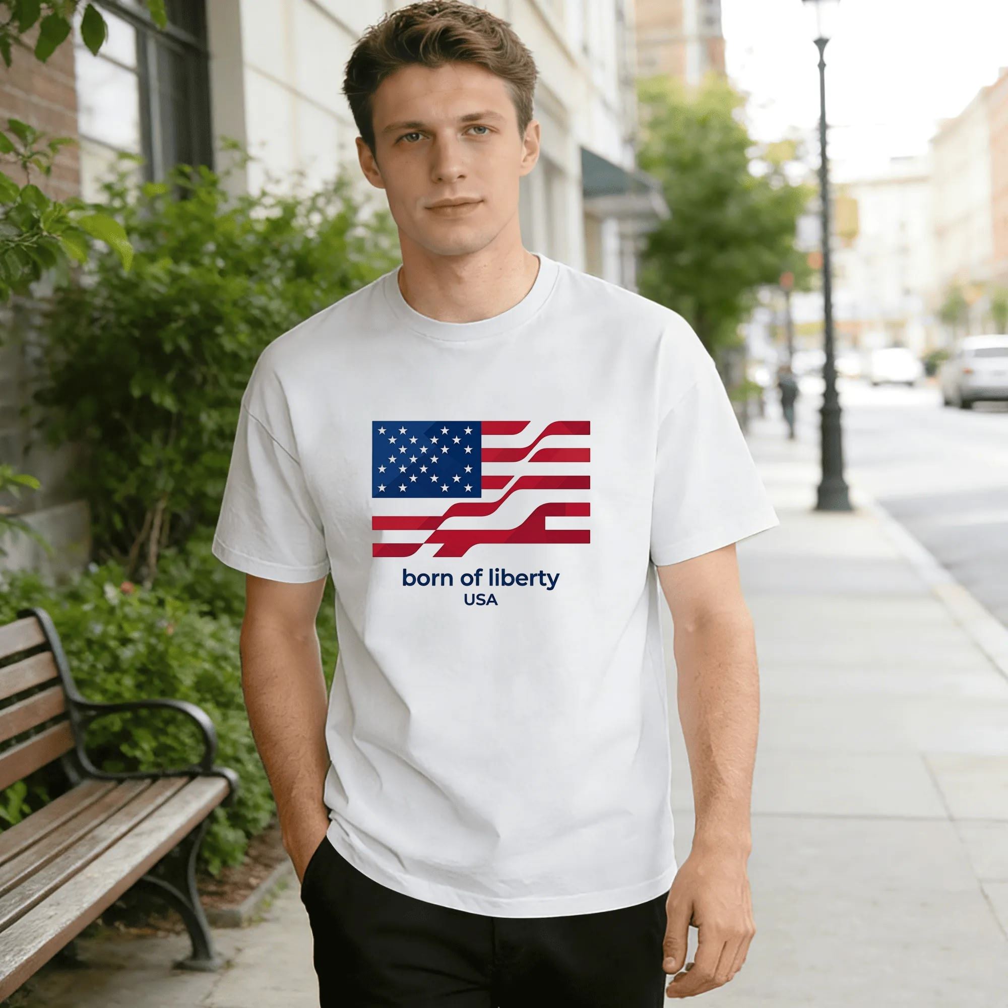 Lifestyle shot of a man wearing the white "born of liberty USA" geometric flag T-shirt on a city street.