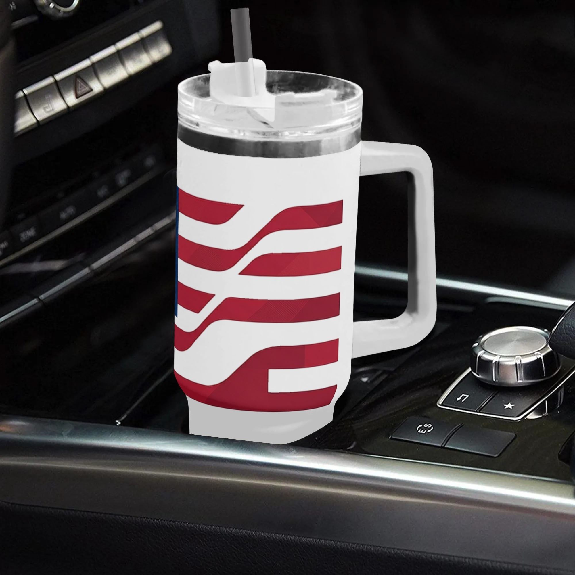 White 40oz handle tumbler with wavy USA flag print placed in car gear shift, Born of Liberty USA 250th insulated travel mug