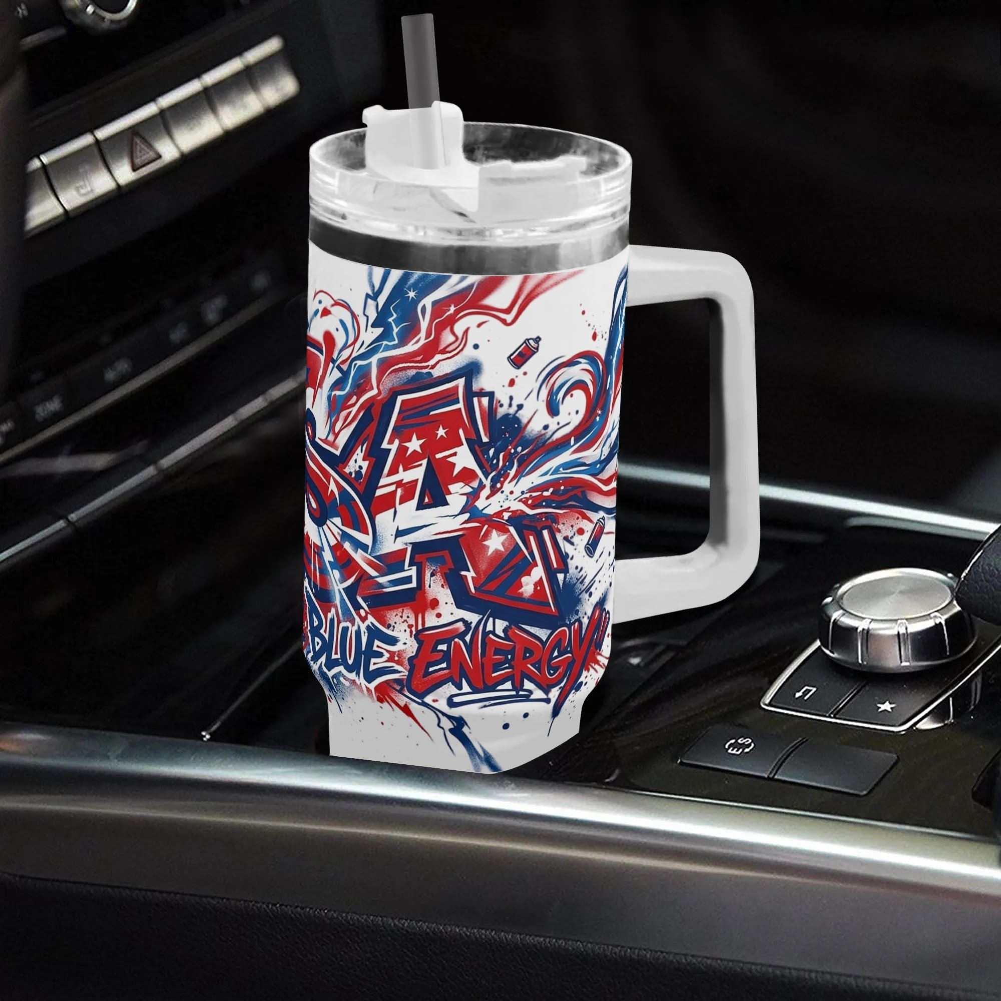 40oz USA 250th semiquincentennial tumbler with handle placed in car gear shift console, street spray paint graffiti USA star stripe "Red White Blue Energy" full wrap insulated stainless steel travel mug