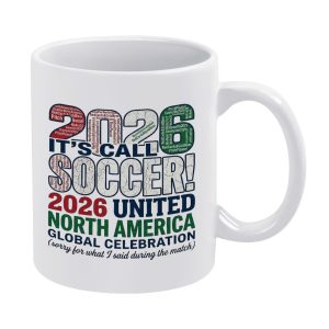 White ceramic mug with a distressed “It's Called Soccer! 2026 North America United” word cloud print, featuring “2026” numbers filled with soccer fan phrases and the humorous tagline “sorry for what I said during the match.”
