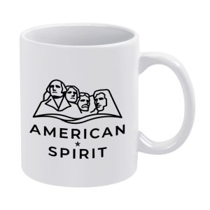 White 11oz ceramic mug with a minimalist black line art print of Mount Rushmore and the text "AMERICAN SPIRIT".