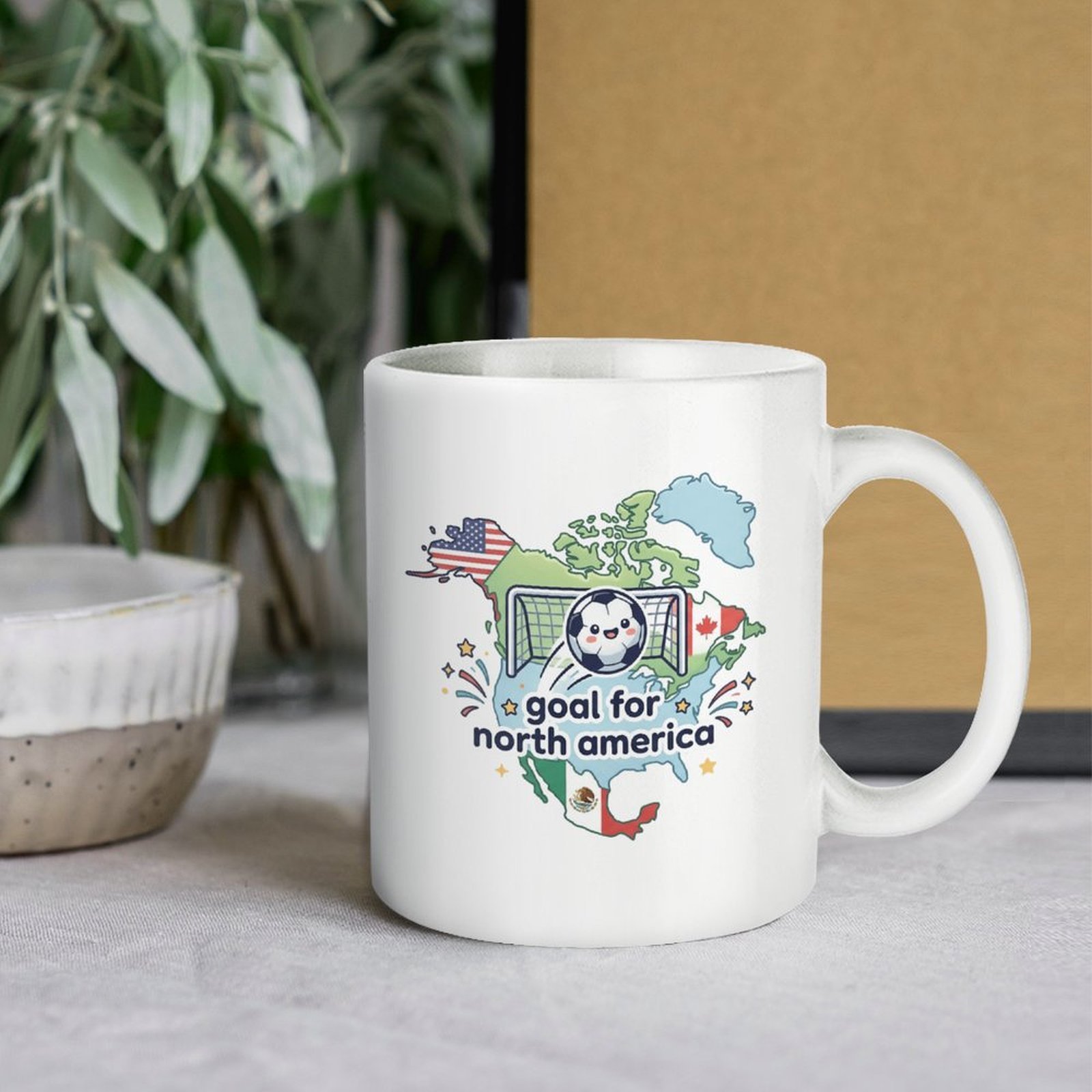 Lifestyle shot of the mug on a table, paired with plants, highlighting the cute North America soccer design