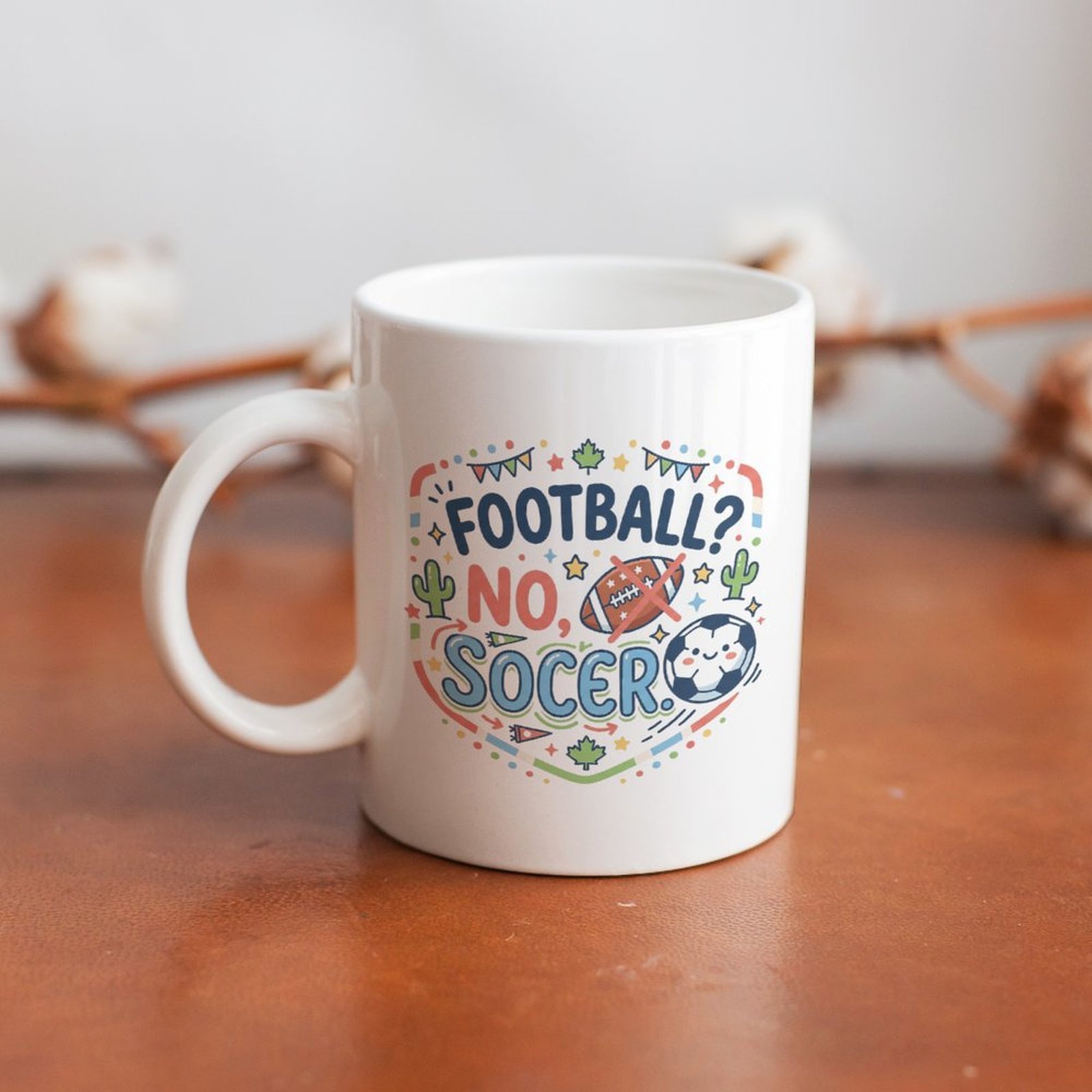 The mug displayed on a wooden table, highlighting the bright, cartoon-style soccer slogan design under soft natural light.
